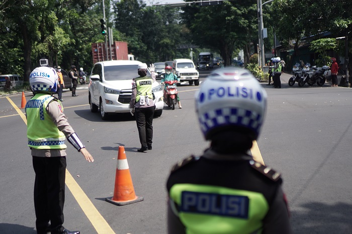 Anggota Kepolisian menghentikan kendaraan berplat nomor luar kota saat Operasi Penyekatan di Pospam /MOHAMMAD AYUDHA/ANTARA FOTO