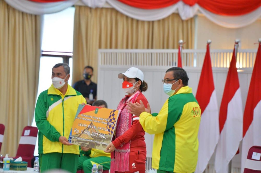 Gubernur Riau (kiri) didampingi Wakil Gubernur Riau (paling kanan) memberikan bonus sebesar Rp1 mili