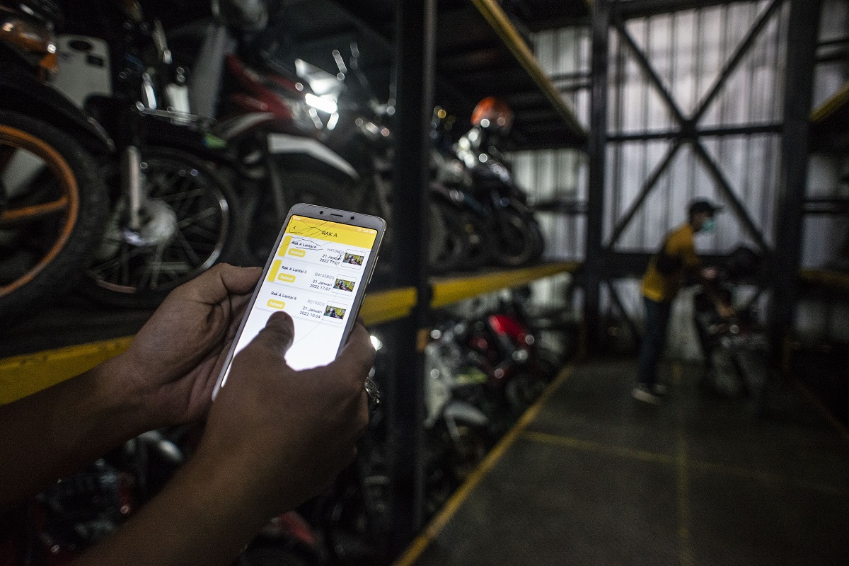 Pekerja mengakses aplikasi saat akan menurunkan sepeda motor di Soul Parking, Kebon Kacang, Jakarta,